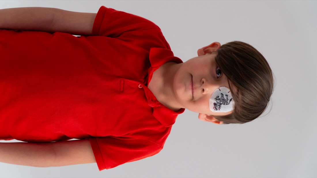 A young child wearing an amblyopia treatment patch